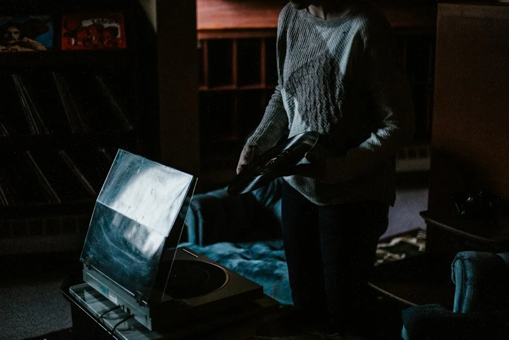 Seseorang menulis di laptop di ruangan gelap di depan layar