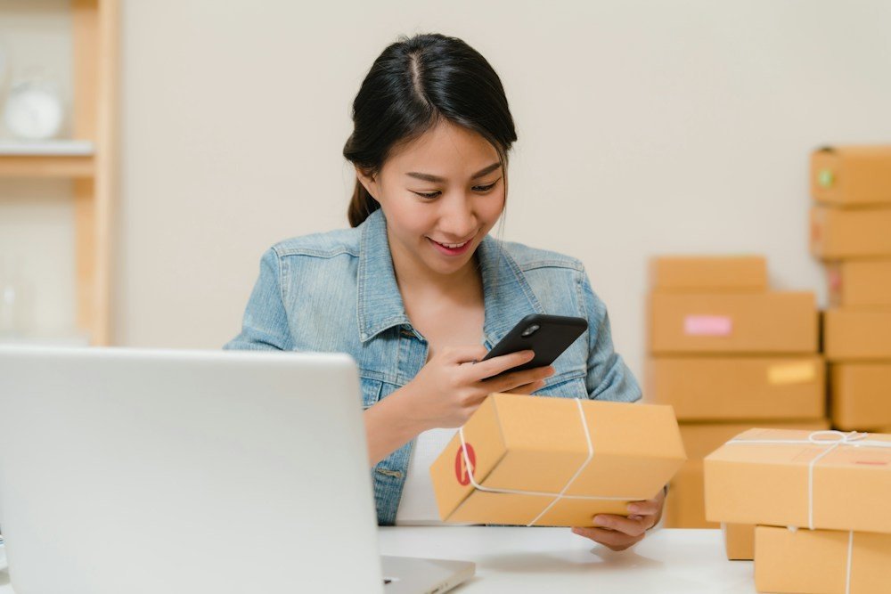 Pemilik toko kecil menyiapkan paket pesanan untuk dikirim
