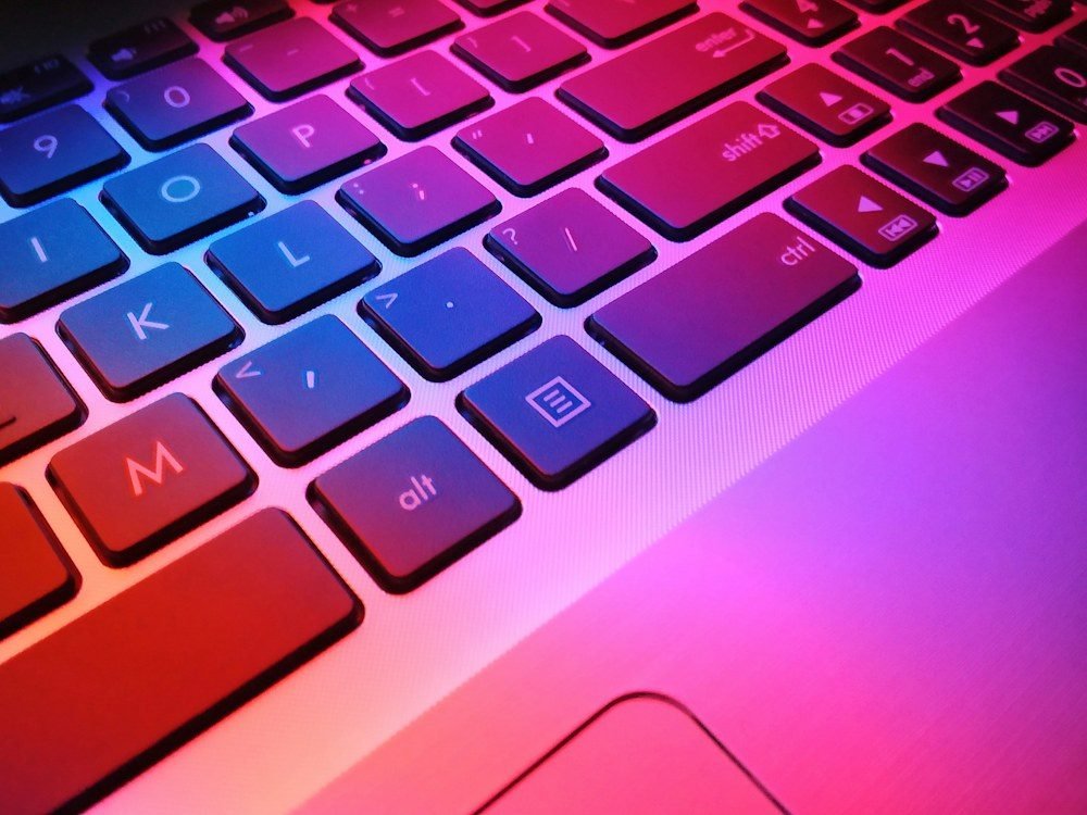 Layar laptop dan papan ketik di atas meja kerja