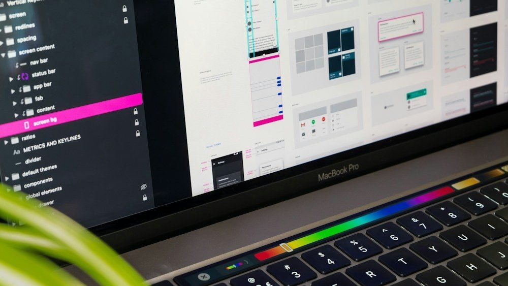 Desainer merancang antarmuka aplikasi di layar laptop
