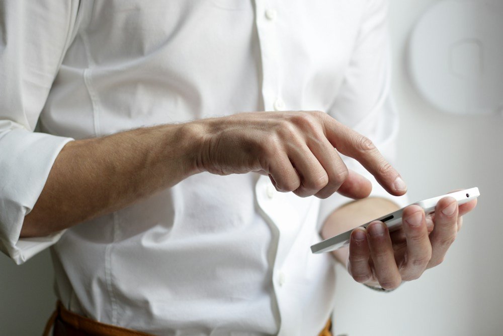 Pemilik toko online memeriksa pesanan lewat ponsel di meja kerja
