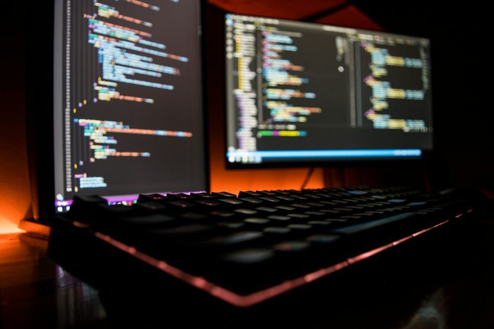 Pengembang web memeriksa baris kode keamanan di laptop kerja